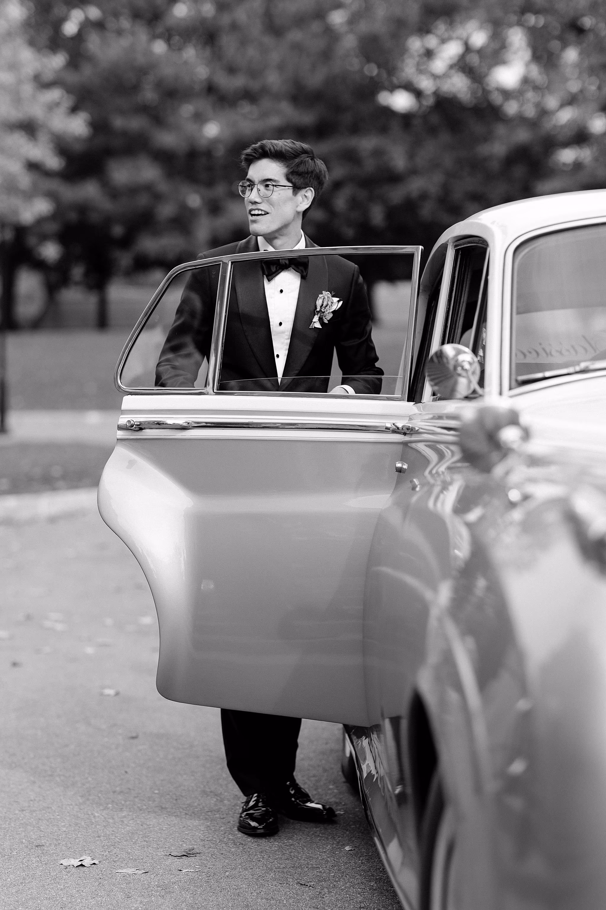 Groom posing next to the car