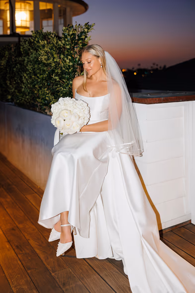 Bride posing with bouquet on a balcony at sunset at Lido House