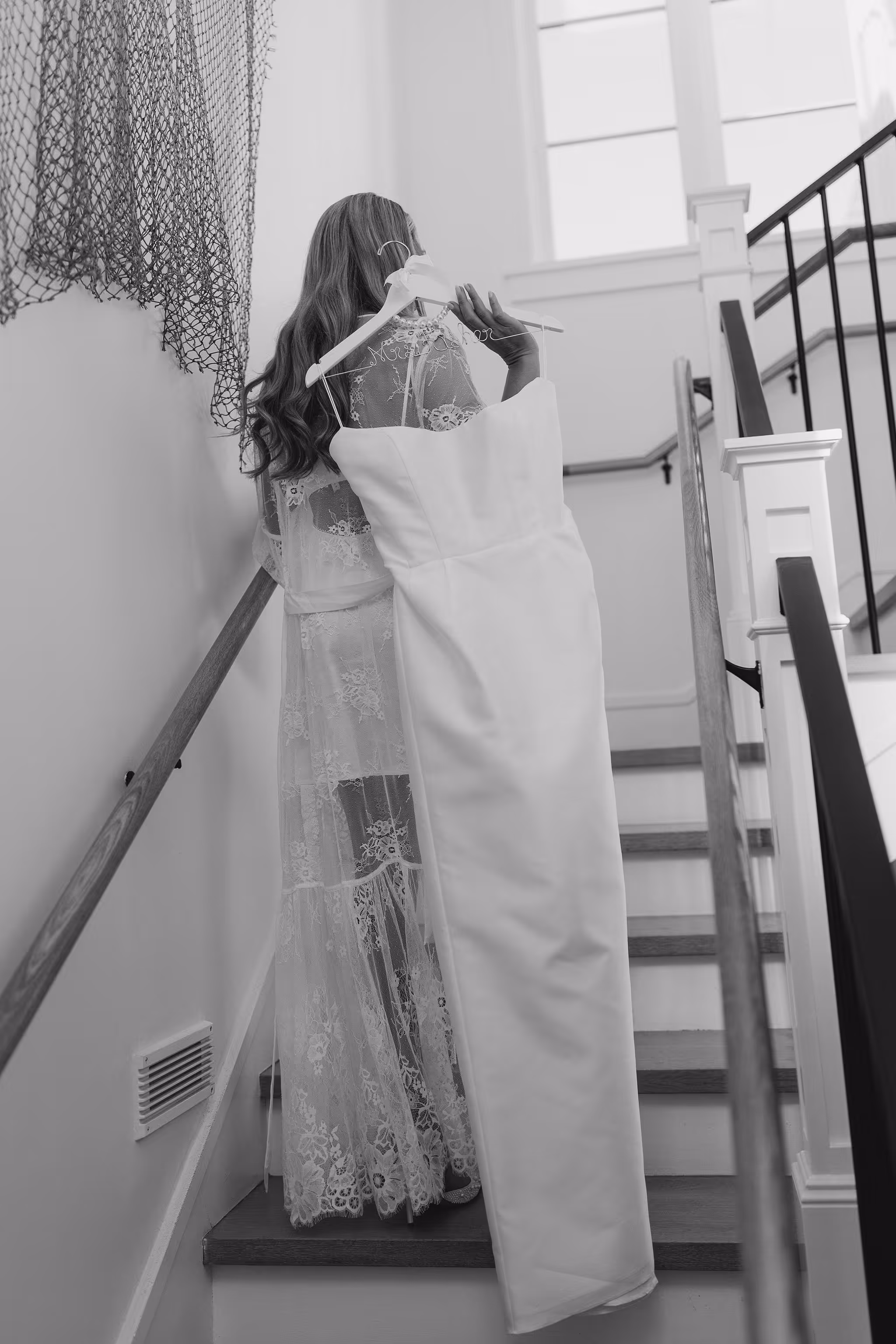 Bride adjusting wedding dress on staircase at Lido House