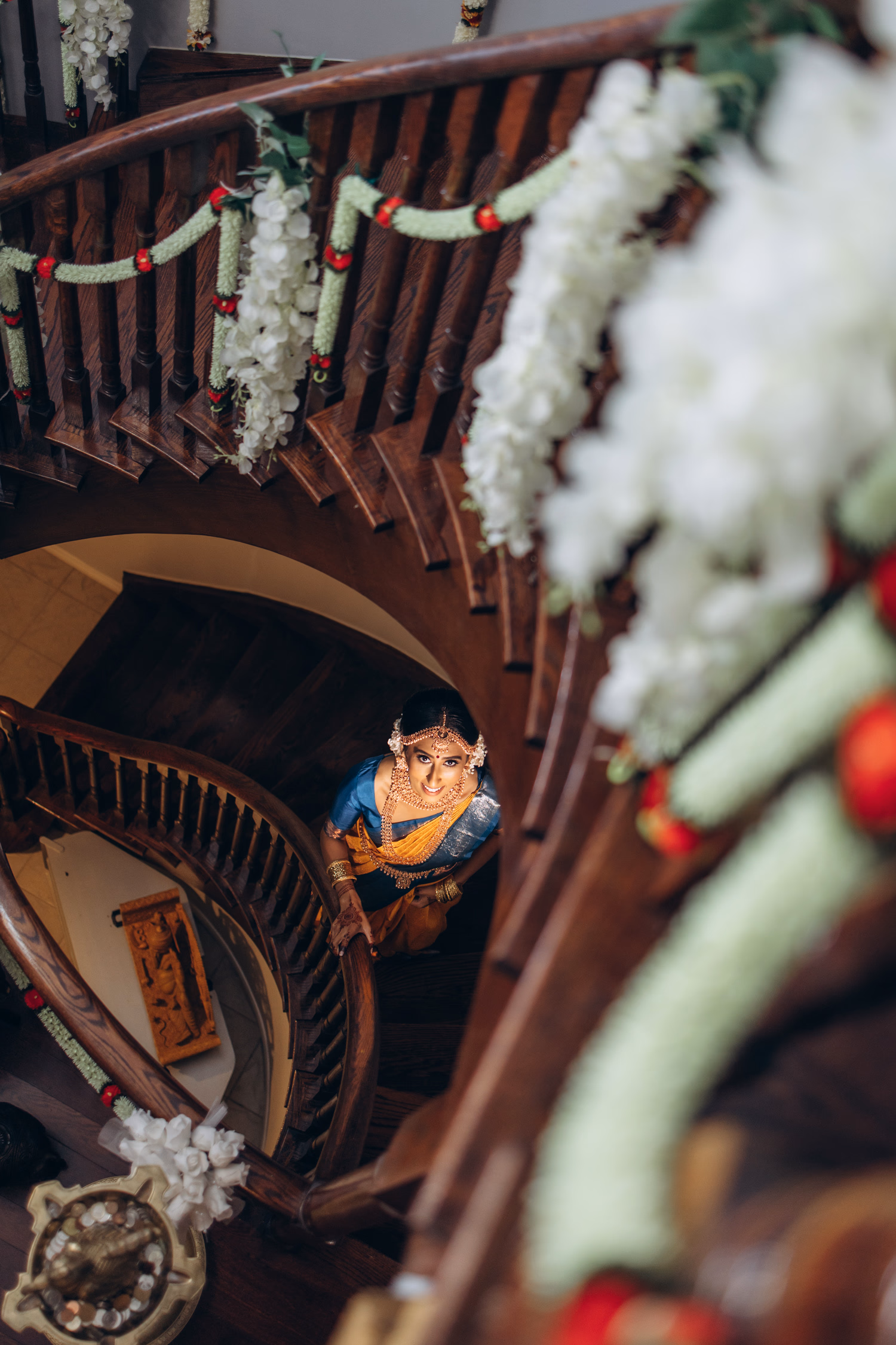 Bride walking down staircase at Tamil wedding venue in Toronto decorated with jasmine garlands
