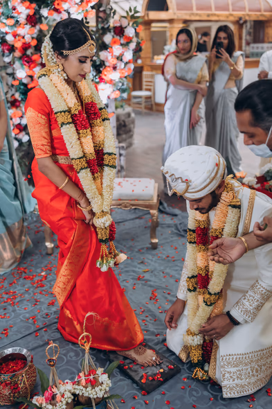 Couple performing fire ritual at Tamil Hindu wedding in greenhouse wedding venue