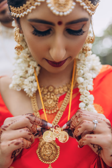 Bride holding thaali necklace during Tamil Hindu wedding ceremony