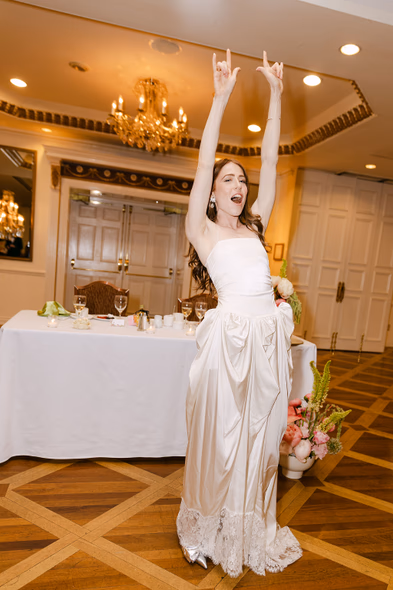 bride celebrating arms up reception moment Imperial Ballroom Queen’s Landing wedding