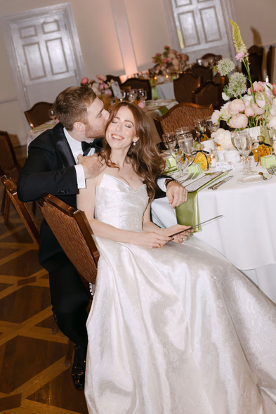 bride and groom seated at reception table candid joyful moment