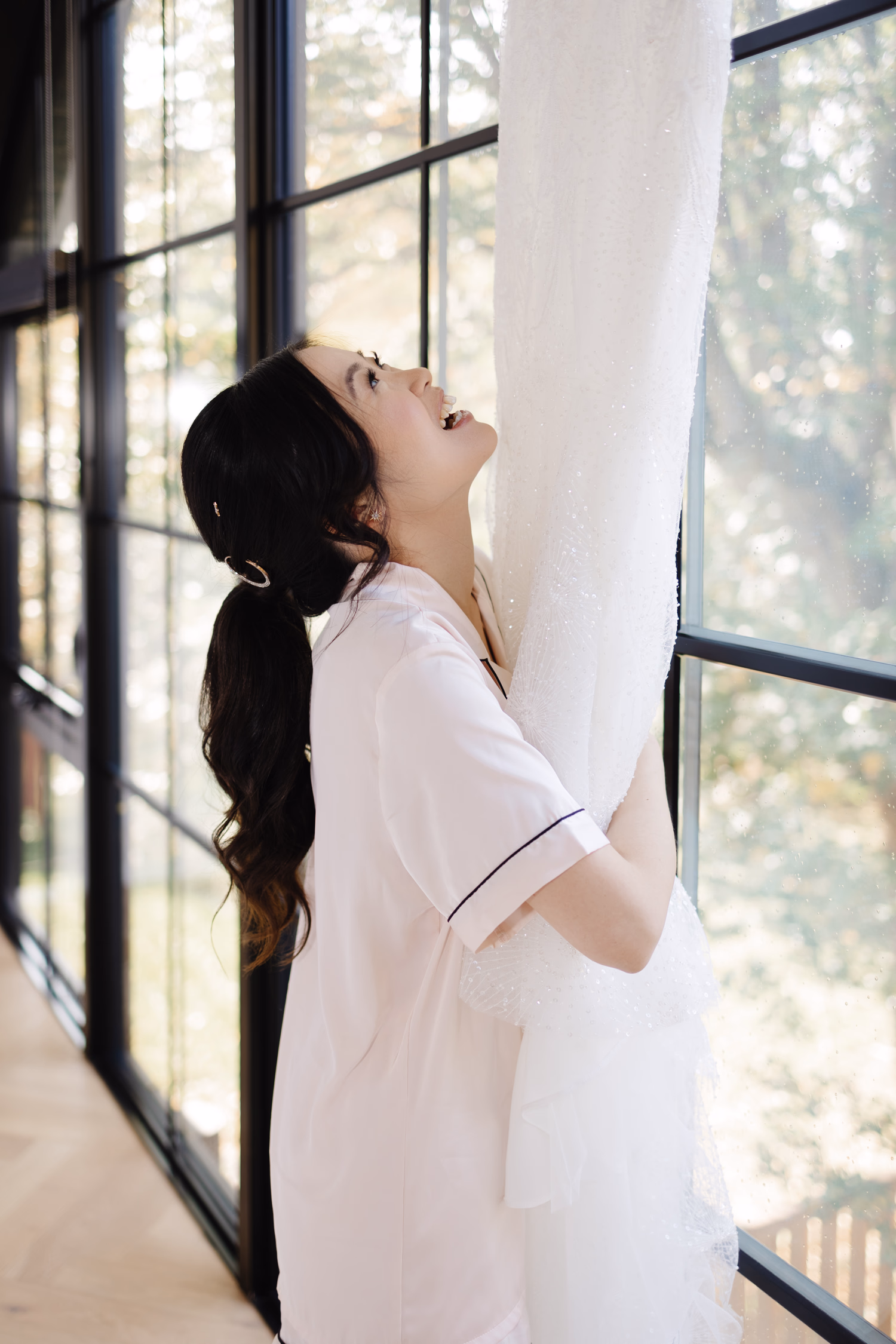 Bride admiring hanging wedding dress