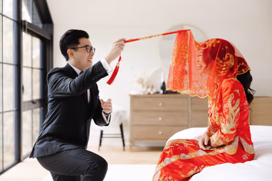 groom lifting red veil
